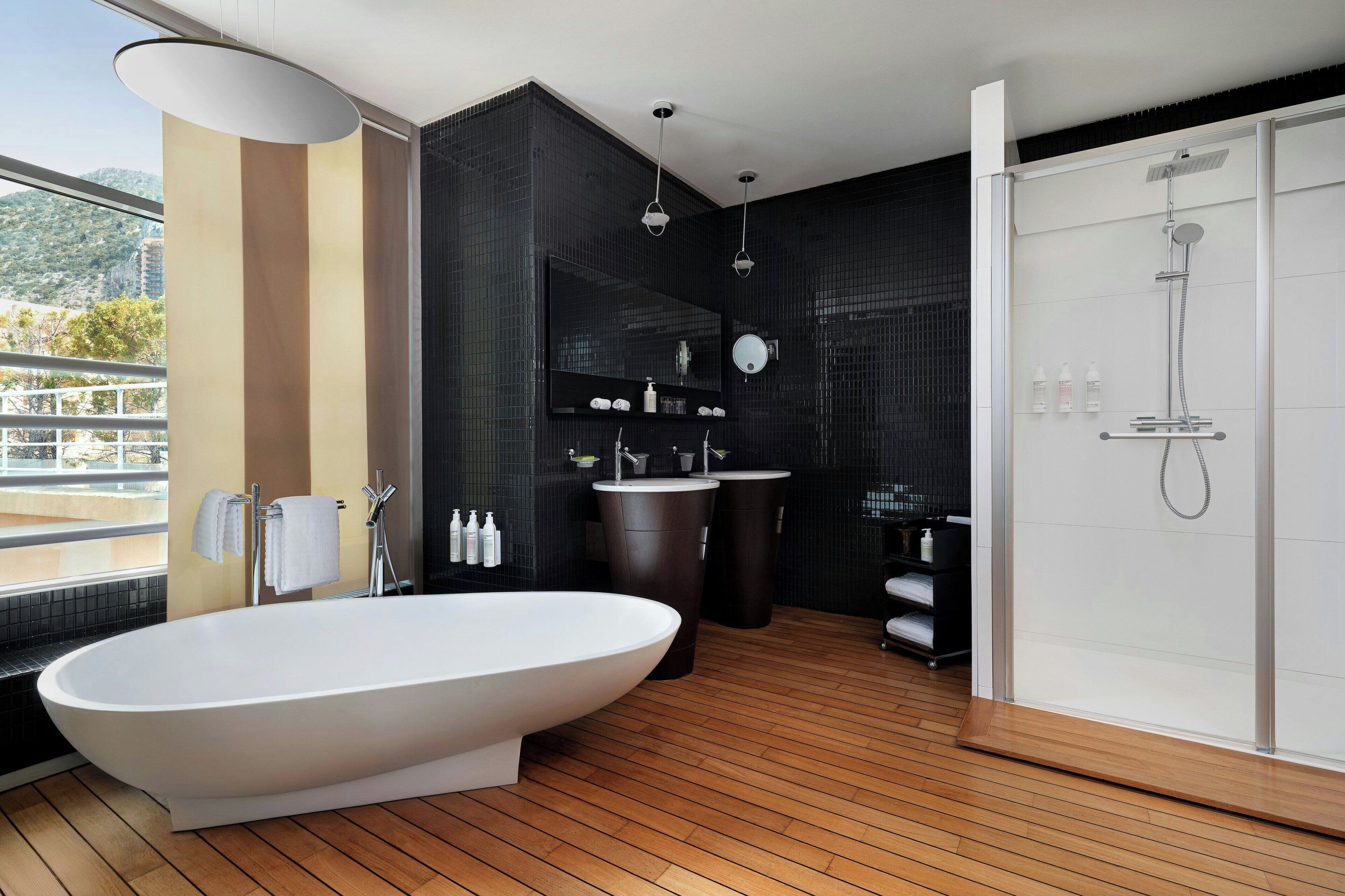 A modern bathroom with a freestanding bathtub, a large mirror, and a walk-in shower.