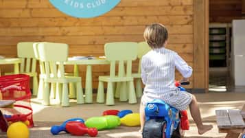 Ein Spielbereich aus Holz für Kinder mit einem Schild, auf dem 'Meriden Family Kids Club' steht.