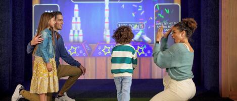 A bowling game with a digital scoreboard, a play clock, and a target for toppling bottles.
