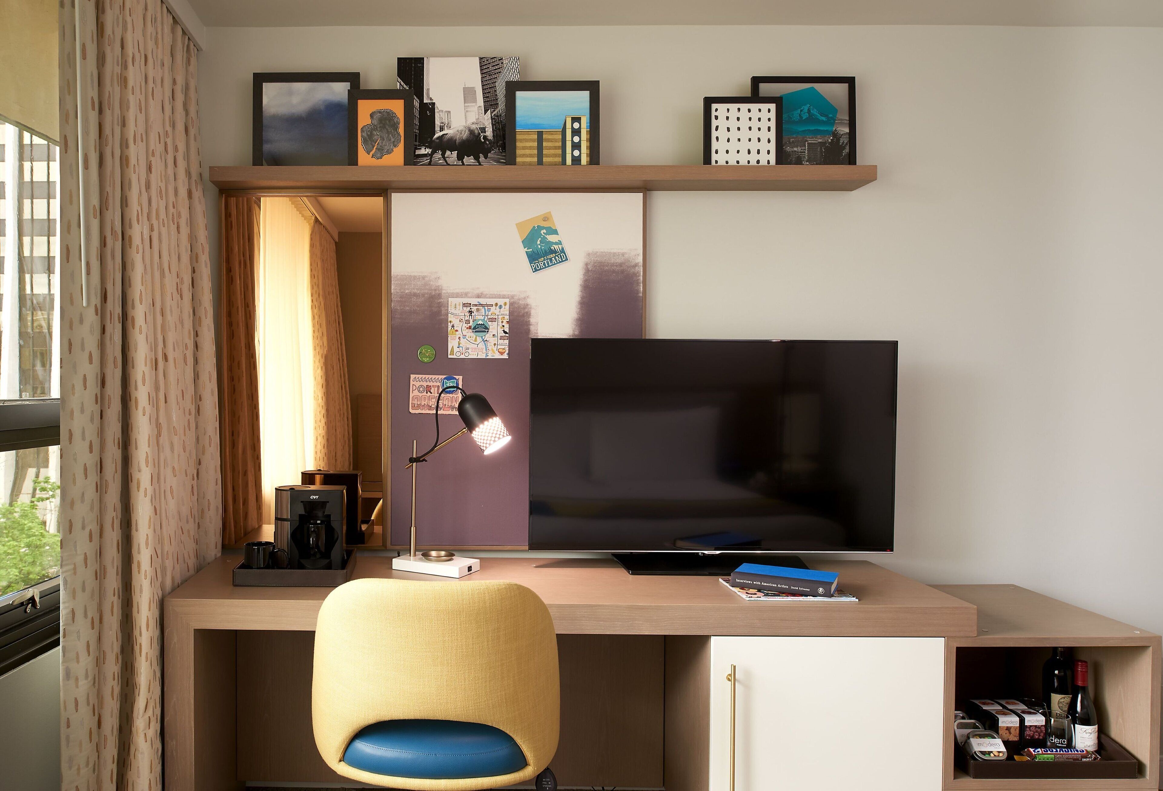 A modern office space with a desk, chair, and a flat-screen TV.