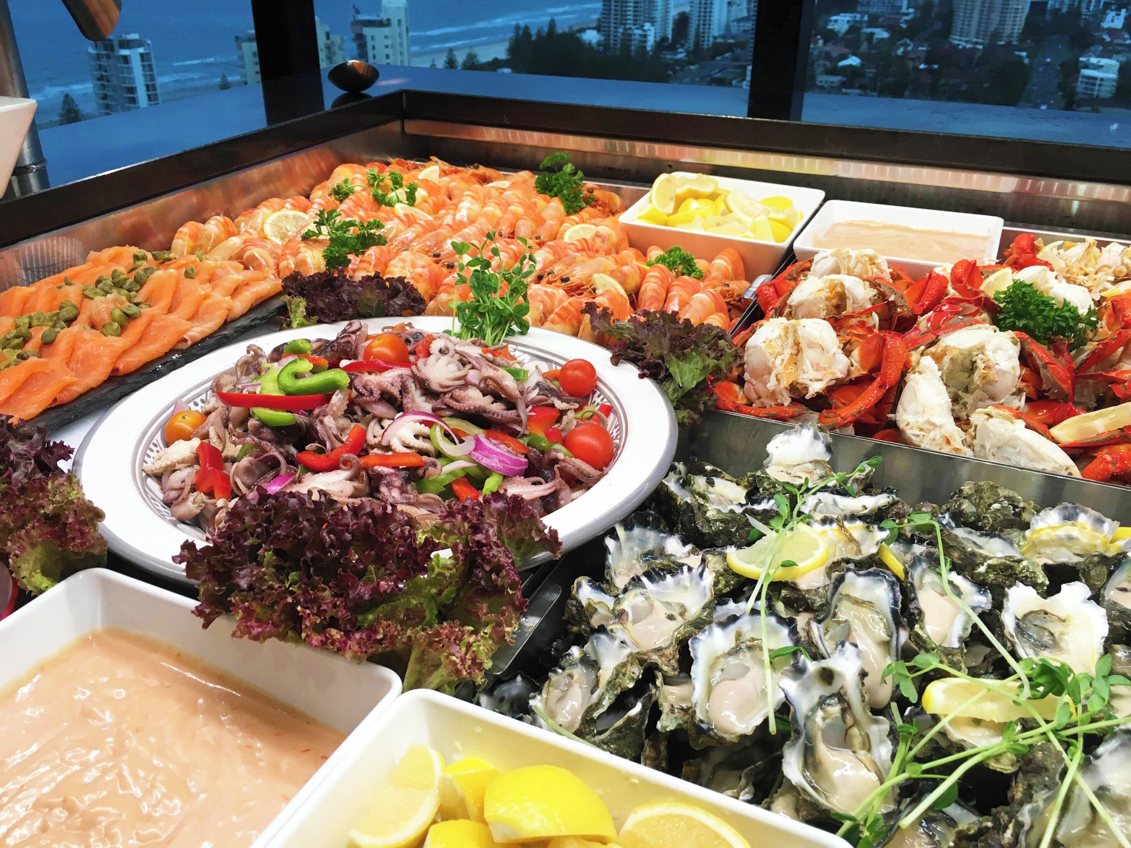 A seafood buffet with various dishes including shrimp, crab, and oysters.