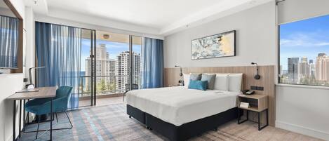 Habitación de hotel moderna con una cama grande, un escritorio y vistas a la ciudad.