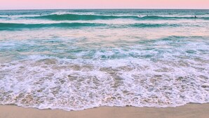 Una playa con olas y cielo despejado.