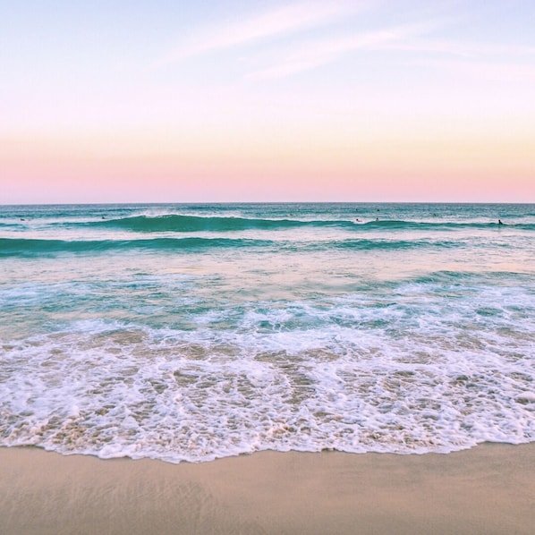 Une plage avec des vagues et un ciel dégagé.
