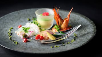A plate of food with various items including shrimp, fish, and vegetables.