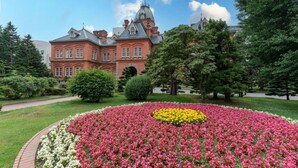 A large building with a prominent dome and a well-maintained garden with colorful flower beds. - ANA Crowne Plaza Sapporo by IHG (Sapporo)