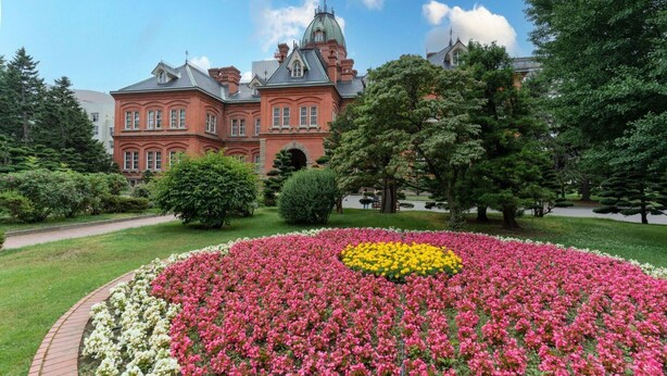 A large building with a prominent dome and a well-maintained garden with colorful flower beds. - ANA Crowne Plaza Sapporo by IHG (Sapporo)