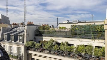 Terraza en la azotea con plantas en macetas y vistas a la Torre Eiffel.