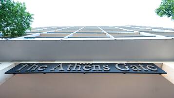 Ein Schild mit der Aufschrift „The Athens Gate“ in modernem architektonischen Design.