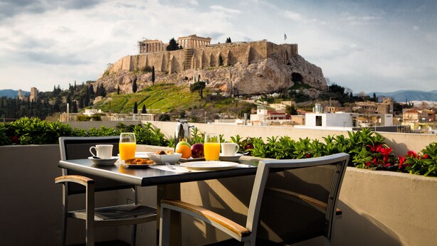 A table with breakfast items and a view of an ancient fortress.
