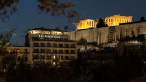 The Athens Gate with classical architecture and a modern building in the foreground.