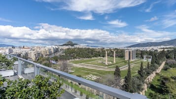 Paisagem urbana com um monumento histórico imponente, edifícios modernos e céu claro.
