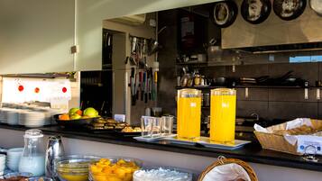 Uma mesa de buffet com diversos alimentos e bebidas.