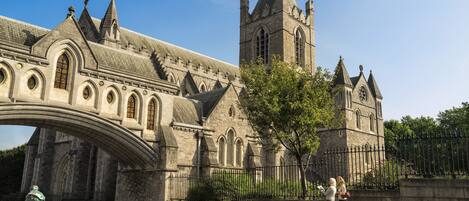 A historic stone building with a prominent tower and arched bridge.