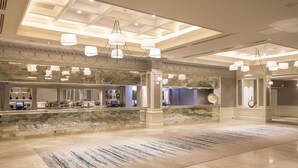 A spacious lobby with a marble floor, a reception area with a counter, and multiple hanging light fixtures. - Clayton Hotel Burlington Road (Dublin)