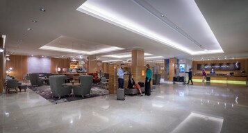 Um saguão de hotel com balcão de recepção, área de estar e lareira.
