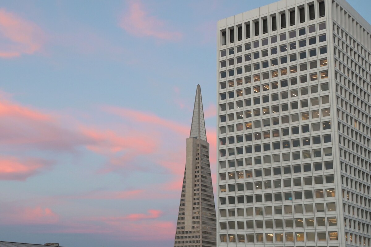 A modern building with a grid-like facade and a pointed spire.