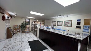 Una zona de recepció amb sòl de marbre, un taulell d'informació i diversos cartells informatius a les parets.