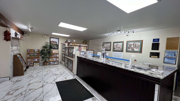 A reception area with a marble floor, a reception desk, and various informational posters on the walls. - Travelodge by Wyndham Truth or Consequences (Truth or Consequences)