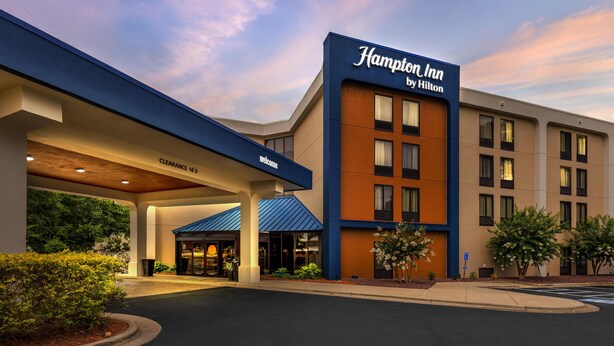 A Hampton Inn by Hilton building with a clear sky.