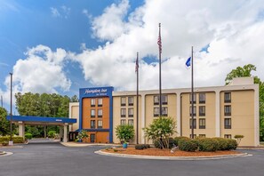A Hampton Inn by Hilton hotel with a clear sky and flags. - Hampton Inn Rocky Mount (Rocky Mount)