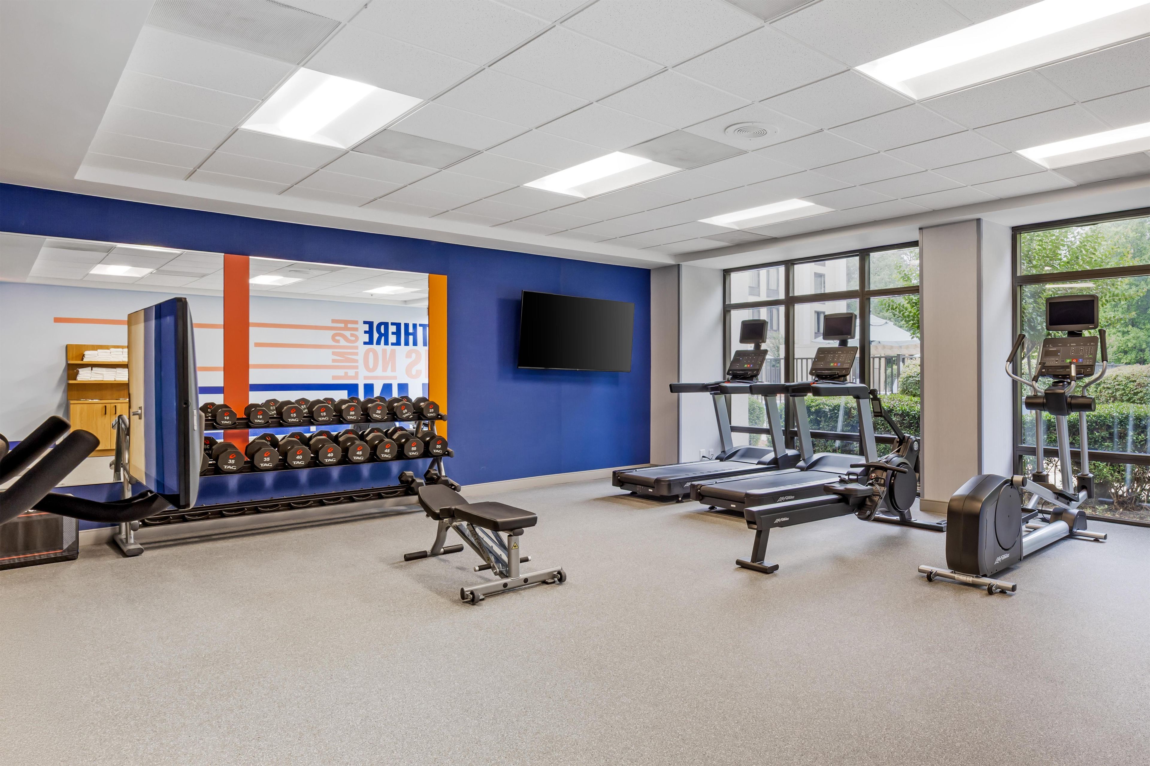 A gym with weightlifting equipment, treadmills, and exercise machines.