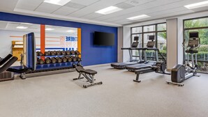 A gym with weightlifting equipment, treadmills, and exercise machines.