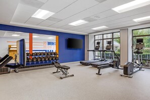 A gym with weightlifting equipment, treadmills, and exercise machines.