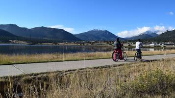 Un sendero pavimentado junto a un lago, con montañas al fondo.