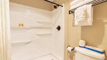 Baño con ducha, inodoro y perchero para toallas.