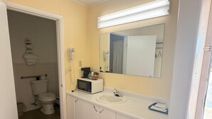 Kylpyhuone, jossa on wc, pesuallas ja peili.