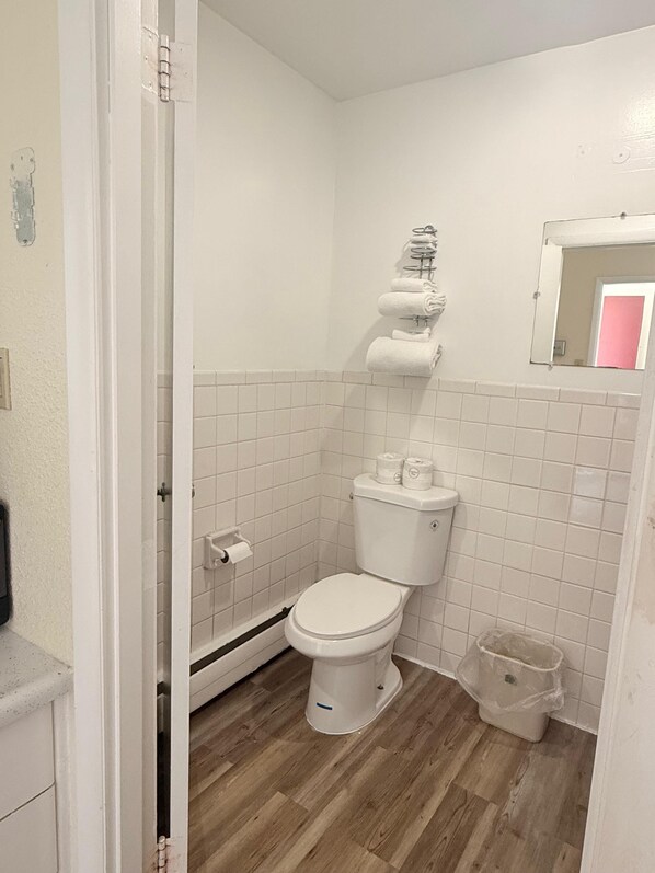 A small bathroom with a toilet, a sink, and a mirror.
