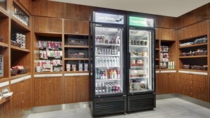 A store with wooden shelving and two refrigerated display cases labeled "Cold Drinks" and "Frozen Foods." - Holiday Inn Westbury - Long Island by IHG (Carle Place)