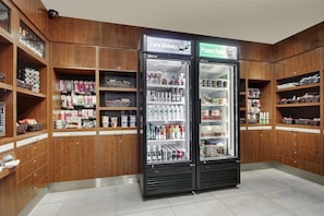 A store with wooden shelving and two refrigerated display cases labeled "Cold Drinks" and "Frozen Foods."