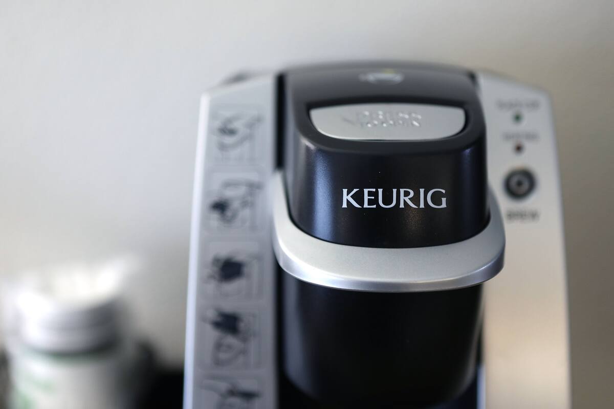 A close-up of a coffee maker with the brand name "KEURIG" visible on the front.