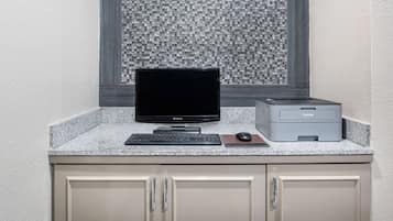 A computer desk with a monitor, keyboard, mouse, and printer.
