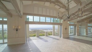 Un intérieur spacieux doté de grandes fenêtres offrant une vue sur la plage et l’océan.