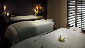 Relax in this serene hotel room with two single beds, a bathtub, and a large mirror.
