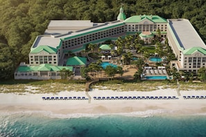 Un complejo turístico con varias edificaciones, una piscina y una zona de playa.