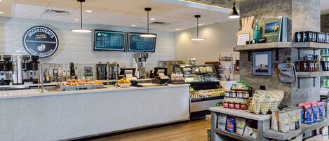 A coffee shop interior with a counter, coffee machines, and a menu board.