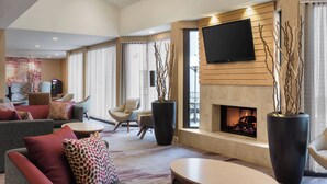 A modern hotel lobby with a fireplace, comfortable seating, and a flat-screen TV. - Courtyard by Marriott Philadelphia Willow Grove (Willow Grove)