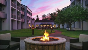A courtyard with a fire pit, outdoor seating, and a building with balconies. - Courtyard by Marriott Philadelphia Willow Grove (Willow Grove)