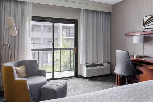 Enjoy a room with a sliding glass door leading to a balcony with views of the surrounding area.