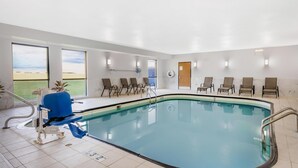 A pool area with a clear view of the sea, a blue chair, and several lounge chairs. - Best Western Forsyth - Decatur (Forsyth)