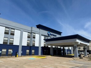 A modern hotel with a 'Best Western' sign, a covered entrance, and a parking lot. - SureStay by Best Western Forsyth Decatur (Forsyth)