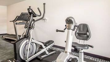 Uma academia com uma máquina elíptica e uma bicicleta ergométrica.