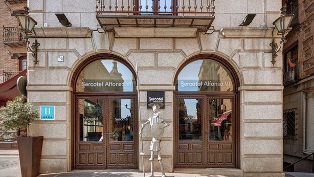 A hotel facade with two large arched windows, a central entrance, and a decorative statue. - Hotel Sercotel Alfonso VI (Toledo)