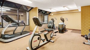A gym with treadmills, an elliptical, and a stationary bike. - Days Inn by Wyndham Cheyenne (Cheyenne)