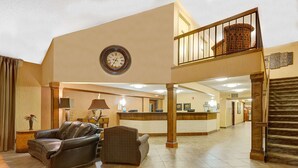 A spacious lobby with a reception desk, leather chairs, a clock, and a staircase. - Days Inn by Wyndham Cheyenne (Cheyenne)