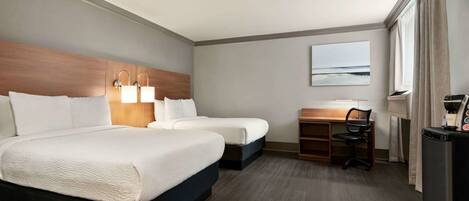 A hotel room with two beds, a desk, a chair, a refrigerator, and a window with curtains.
